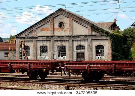 Railway Wagon Composition In Front Of Old Railway Station With Dilapidated Walls And Broken Windows 
