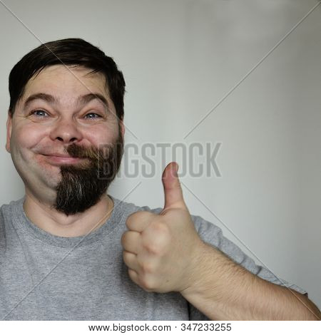 A Bearded Man With Half His Face Shaved Off. Part Of The Face Without A Beard. The Man Smiles, Is Ha