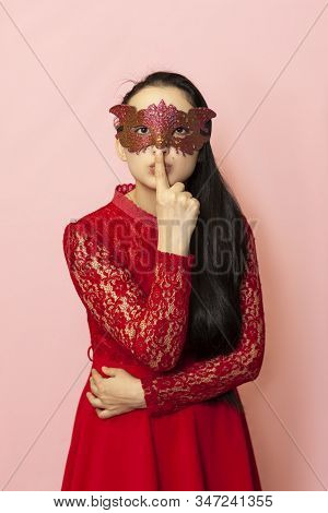 Keep Quiet Sign. Portrait Of A Beautiful Woman In Evening Dress And Masquerade Mask Showing Hand Ges