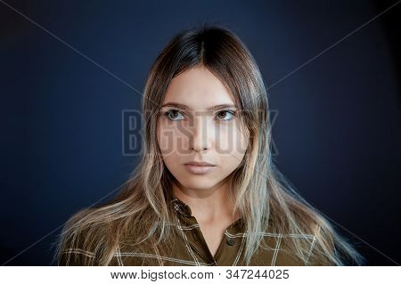 Young White Woman Looks Away, Close-up On Intensely Blue Background. Female Caucasian Ethnicity, 22 