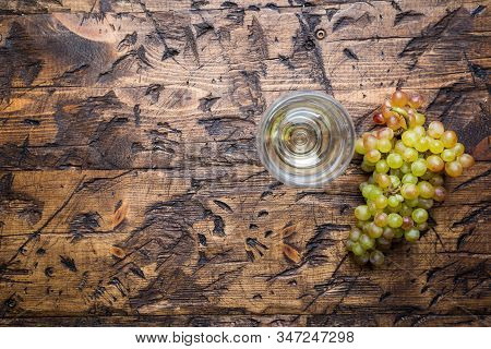 Glass Of White Wine And Ripe Grapes On Wooden Background, Top View