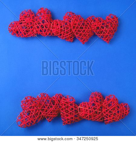 Beautiful Wicker Red Hearts On The Cornflowerblue Background. St Valentines Concept With Copy Space.