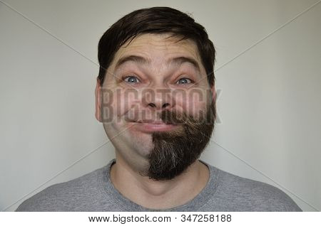 The Bearded Man Smiles, Half Of His Face Shaved Off. Part Of The Face Without A Beard. Portrait Of A