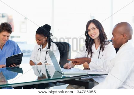 Sonriendo a pasantes médicos trabajando en el equipo junto a compañeros de trabajo
