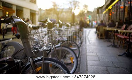 Modern Electrobikes Standing At Parking Near Beautiful Street Cafe, Transport