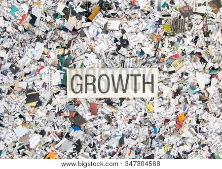 Newspaper confetti from above with the word GROTH background