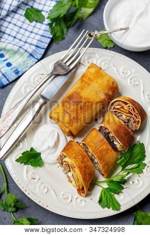 Pancakes Stuffed With Meat, Onion And Egg With Sour Cream. Traditional Russian Dish For A Shrove. To
