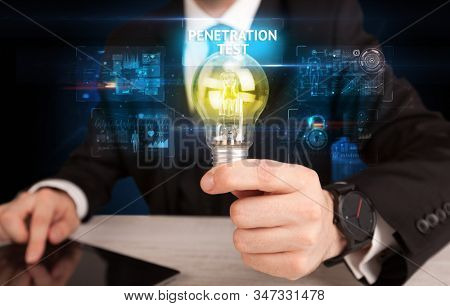 Businessman holding lightbulb with PENETRATION TEST inscription, online security idea concept