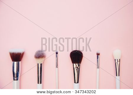 Set Makeup Brushes On Pink Color Background. Top View Point, Flat Lay