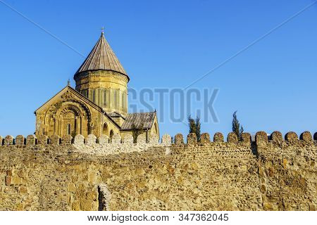 Svetitskhoveli Cathedral, Mtskheta, Georgia. The Dome Of The Cathedral Above The Battlements Against