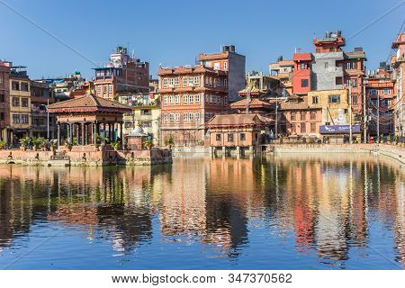 Patan, Nepal - November 15, 2019: Pimbahal Pokhari Krishna Temple And Houses In Patan, Nepal