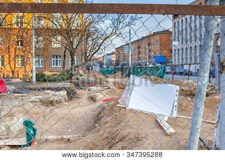 Underground Rennovation Works In City With Protective Fence Wire At Foregound. Horizontal Image Comp