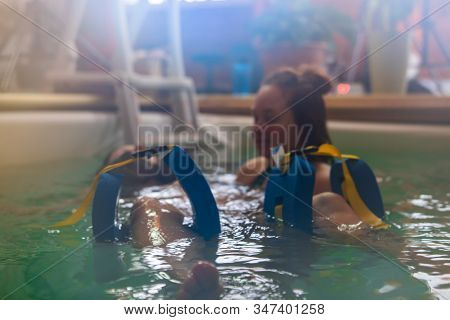 Close-up Of Legs Of Pregnant Woman Locked In Float While Receiving Massage And Exercising In Swimmin