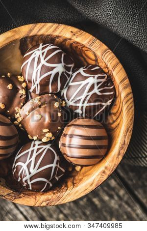 Praline bonbons. Chocolate truffles in wooden bowl.