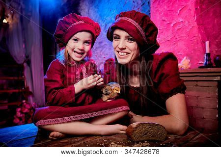 Easter And Family. Mother And Daughter In Maroon Or Red Dresses Of The Village Shepherdesses And Sma