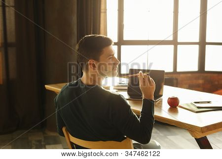 Office Work. Young Entrepreneur Guy Thinking Holding Pencil Working Sitting At Workdesk Indoors. Sel