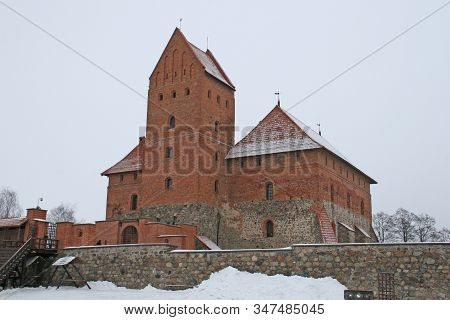 Gothic Red Brick Trakai Castle In Winter Time, In The Middle Of Frozen Lake, Lithuania