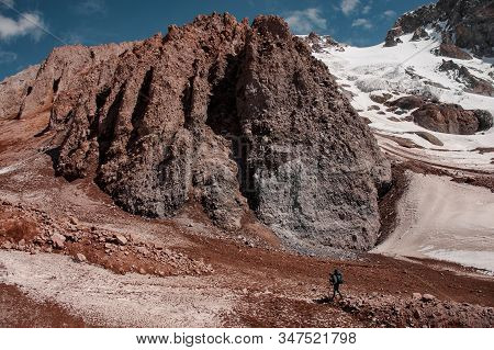 Male Trekker Goes Up The Trail In Mountains