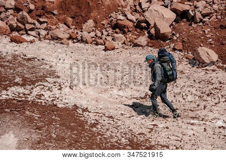 Male Traveller Goes Up The Trail In Mountains