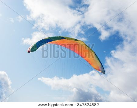 Paraglider Flying On A Background Of Blue Sky And Clouds. Clpseup