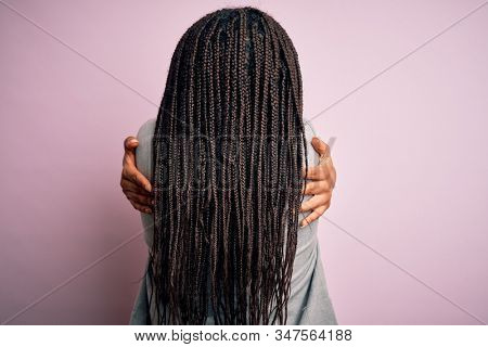 Young african american business woman standing over pink isolated background Hugging oneself happy and positive from backwards. Self love and self care