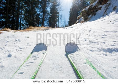 Ski Tourer Ascending A Snowy Road Through Forest.