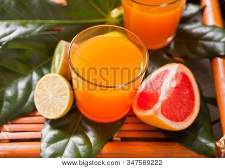 Glasses Of Tropical Exotic Multifruit Juice On A Palm Leaves.