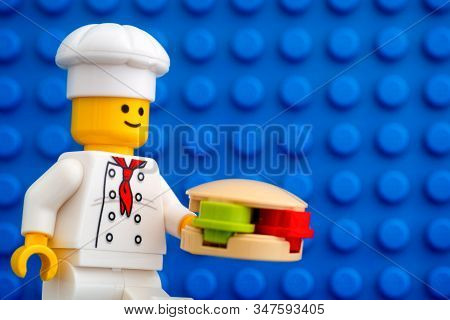 Tambov, Russian Federation - October 19, 2019 Lego Chef Minifigure With Hamburger Against Blue Basep