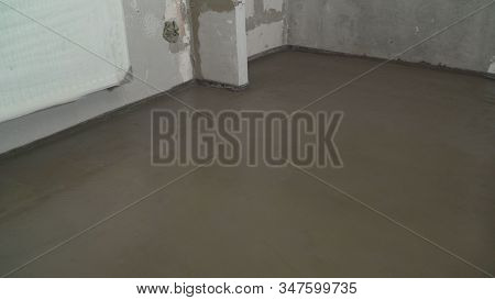 Leveling The Floor With A Long Spatula. Builder Levels A Laid Floor. Floor Laying At Home. The Build