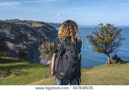 Deba, Gipuzkoa / Spain »; January 26, 2020: A Young Woman Walking Along The Beautiful Coast From Deb