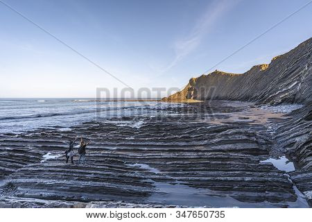 Deba, Gipuzkoa / Spain »; January 26, 2020: Two Young People Impressed On The Coast Of Sakoneta