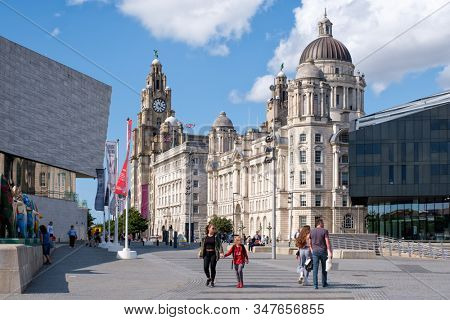 LIVERPOOL,UK - AUGUST 5,2019 : Street secene in Liverpool with a view of the historic Three Graces buildings