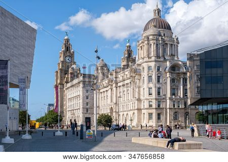 LIVERPOOL,UK - AUGUST 5,2019 : Street secene in Liverpool with a view of the historic Three Graces buildings