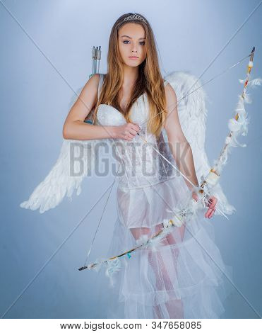 Cute Little Female Cupid Shoots A Bow. Angel Children Girl With White Wings. Innocent Girl With Ange
