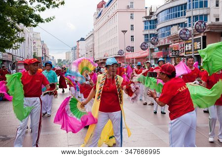China, Heihe, July 2019: A Procession Of People With Fans On The Central Shopping Pedestrian Street,