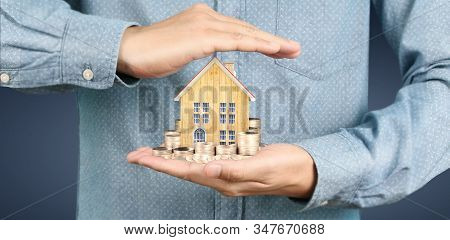 Growing Coins House On Stack Coins In Hand. Concept Of Investment Propert
