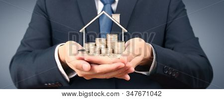 Growing Coins House On Stack Coins In Hand. Concept Of Investment Propert