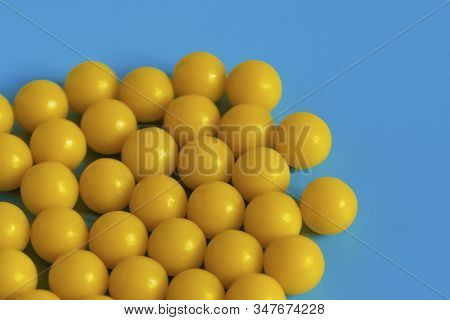 Yellow Vitamins On A Blue Background. Vitamin Complex Against The Virus. Multivitamins To Enhance He