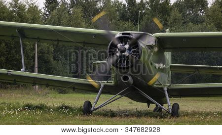 Agricultural Airplane Stands In A Field In The Green Grass.