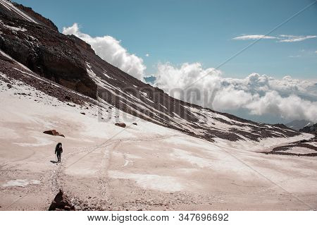 Man Walking On The On The Dirty Snow Path Climbing On The Mountain
