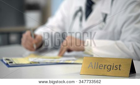Male Allergist Completing Medical Document On Laptop, Consulting Patient Online