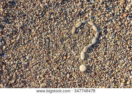 Question Mark Lined With Stones On A Background Of Pebbles. Stones Background.
