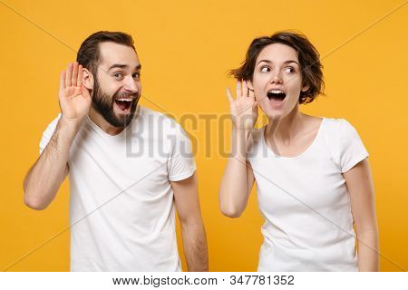 Curious Young Couple Friends Bearded Guy Girl In White Empty T-shirts Posing Isolated On Yellow Oran