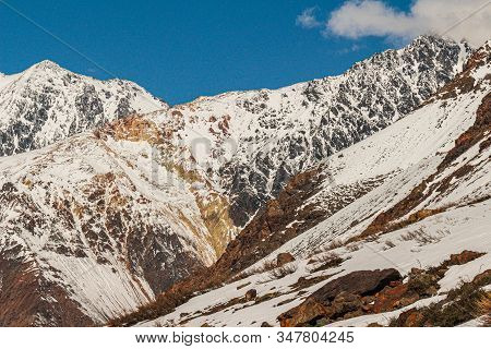 Natural Monument El Morado, Central Andes Of Chile. A Snowy Mountain Slopes And Big Rocky Mountains