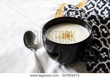 Cauliflower Soup (creme Du Barry) In Black Bowl On White Background With Black And White Cloth. Fren