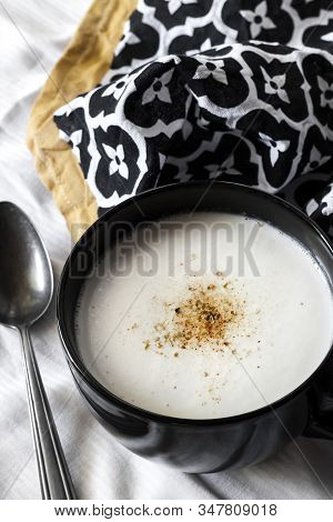 Cauliflower Soup (creme Du Barry) In Black Bowl On White Background With Black And White Cloth. Fren