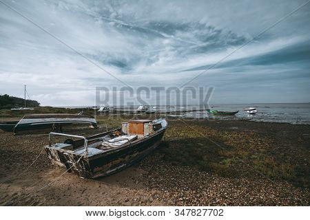 A Wide-angle Landscape With Multiple Old Wooden Fishing Boats On The Shallow Bank Of The River On A 