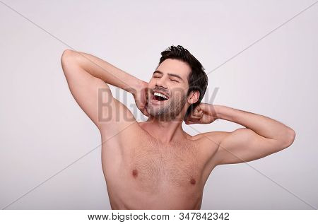 Perfect Skin. Portrait Of Charming Topless Guy Is Standing Against Light Background And Demonstratin
