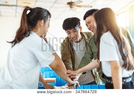 Collage Student  Putting Their Hands On Top Of One Another