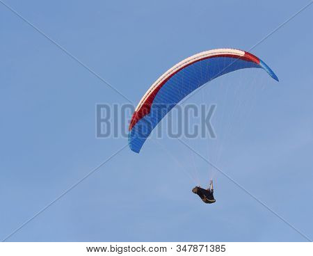 Paraglider Is Flying Against The Blue Sky